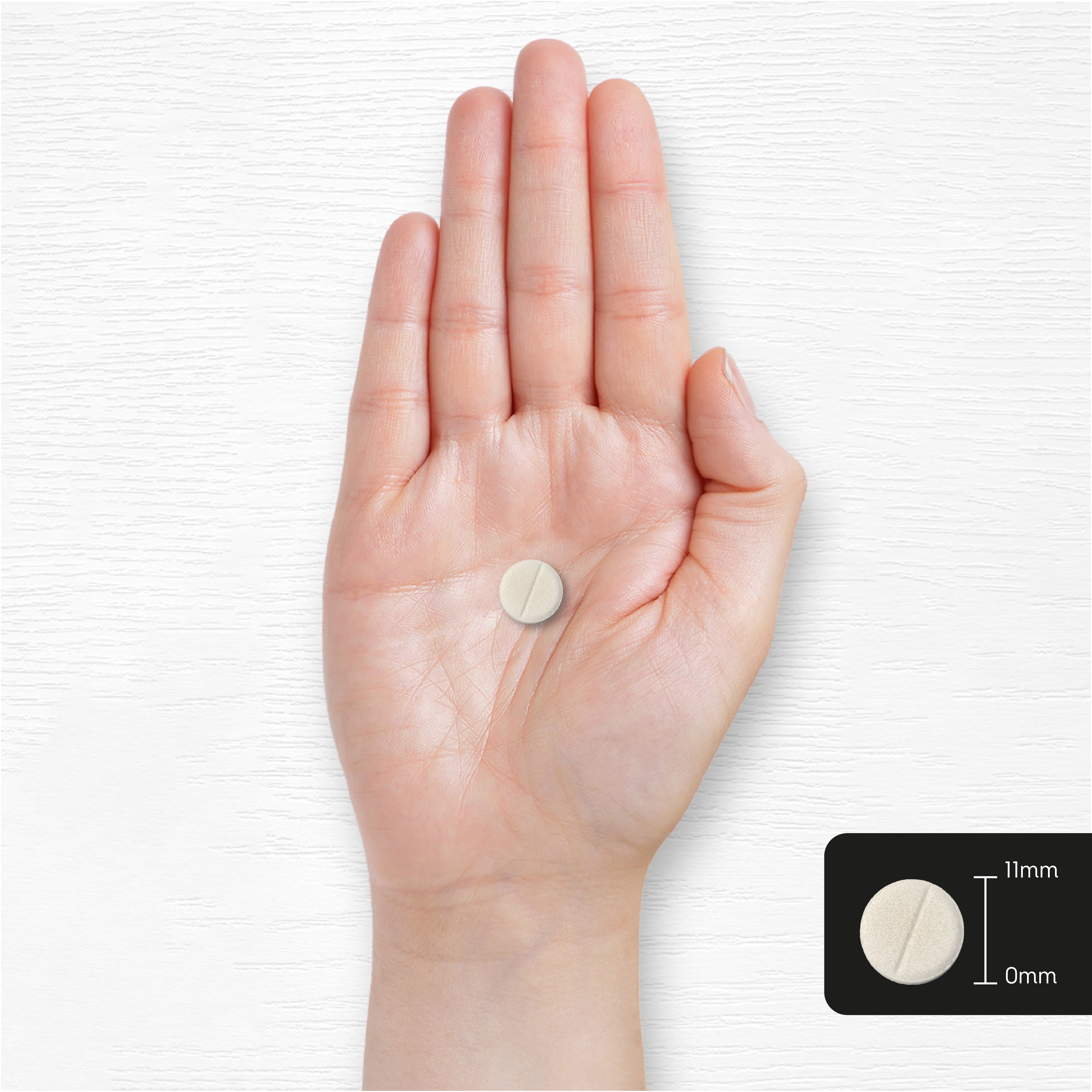 A round CU multivitamin and mineral tablet, 11mm in diameter, held in a hand.