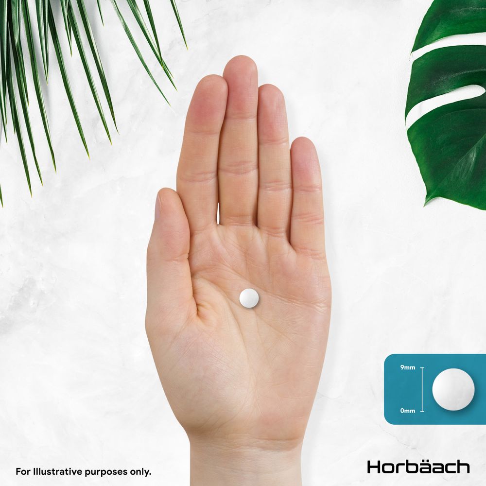 Round white tablet, 9mm in diameter, resting in a hand's palm.