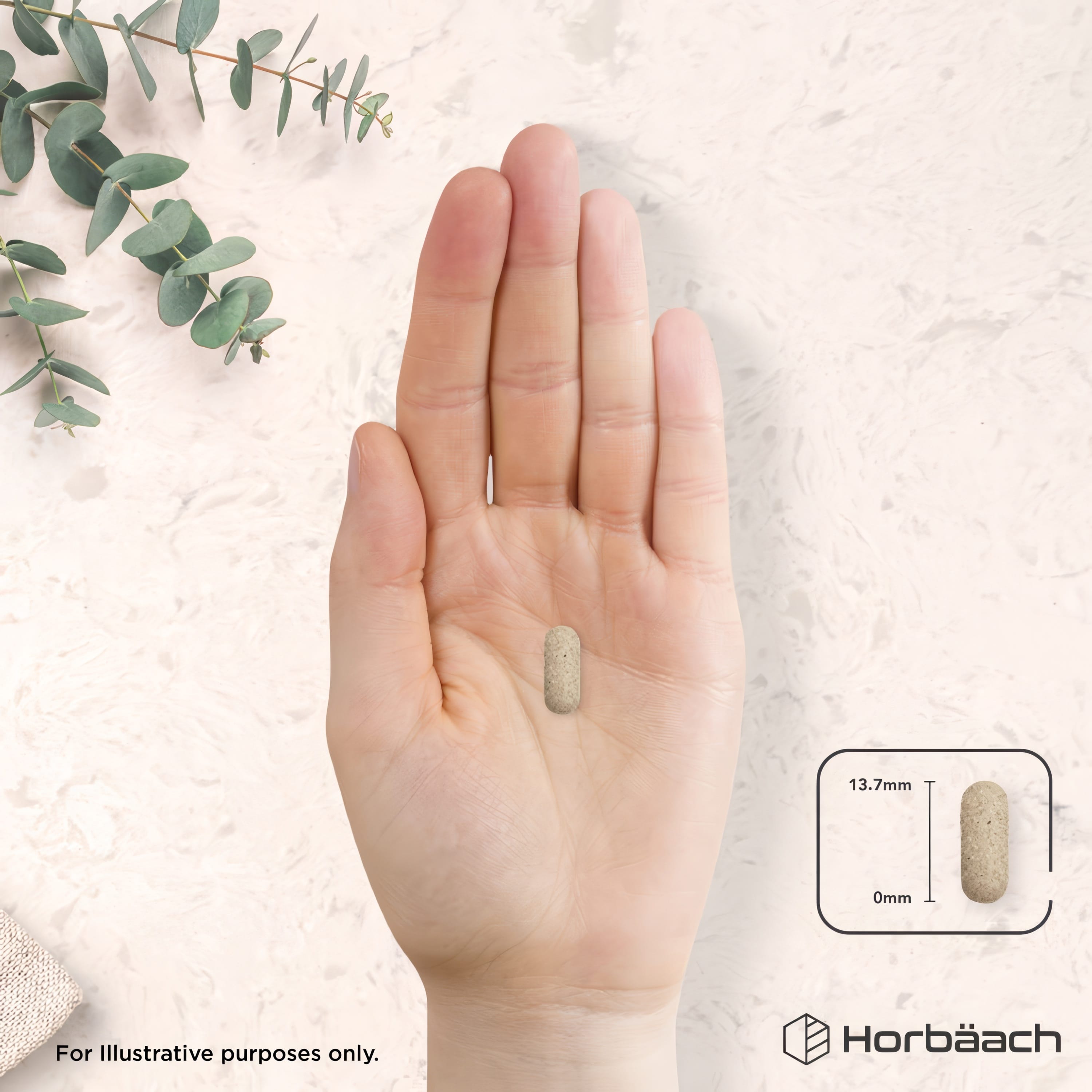 A beige speckled tablet, measuring 13.7mm, is held in a hand.